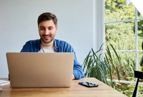 Man-smiling-at-desk-with-computers-2